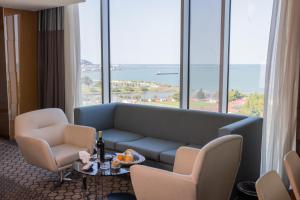 a living room with a couch and chairs and windows at Anemon Samsun Hotel in Samsun