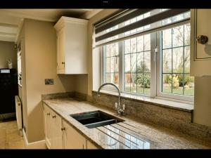 eine Küche mit einem Waschbecken und einem Fenster in der Unterkunft Brackenborough Lakes Resort in Louth