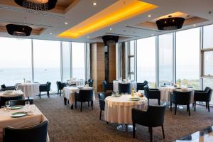 a dining room with tables and chairs and windows at Anemon Samsun Hotel in Samsun