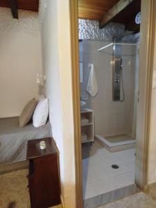 Habitación con baño con cama y ducha. en Almmos, en Kalamaki