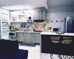 une cuisine avec des placards blancs et un comptoir dans l'établissement PdLuz Casa Completo e Confortável, à São Paulo