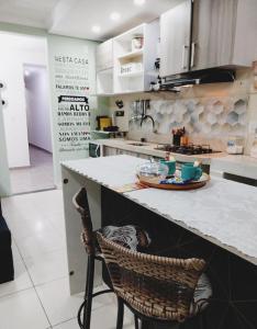 une cuisine avec un comptoir et une chaise dans l'établissement PdLuz Casa Completo e Confortável, à São Paulo