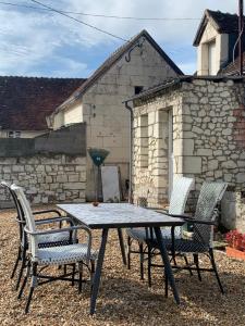 une table et des chaises devant un bâtiment en pierre dans l'établissement Les Amis de Beauval, à Seigy