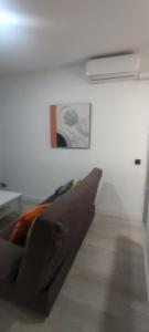 a bedroom with a couch and a painting on the wall at Travel and Holidays San Nicolas in San Sebastián de los Reyes