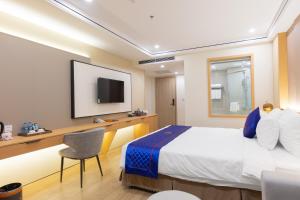 a hotel room with a bed and a tv at Sunshine Apartment Hotel in Móng Cái