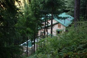 a house in the middle of a forest at Kudrat - A Boutique Homestay- Tirthan Valley in Banjār