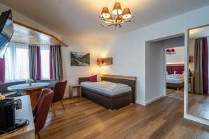 ein Wohnzimmer mit einem Bett und einem Esszimmer in der Unterkunft Hotel Weißbräu in Oberhaching