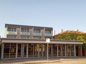 a building with glass doors in front of it at Semaphore Splash Apartments in Port Adelaide