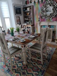 a dining room with a table and chairs on a rug at Harbour View B&B in Bridlington