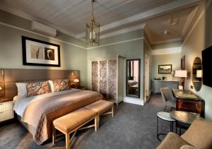 um quarto com uma cama e uma sala de estar em The Winchester Hotel by NEWMARK em Cidade do Cabo