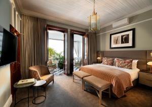 Habitación de hotel con cama y silla en The Winchester Hotel by NEWMARK, en Ciudad del Cabo