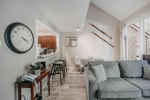 a living room with a couch and a clock on the wall at 45SW-Fireplace-Dishwasher-Washer Dryer-Sleeps 4 condo in Glacier