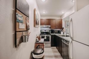 a kitchen with wooden cabinets and a white refrigerator at 45SW-Fireplace-Dishwasher-Washer Dryer-Sleeps 4 condo in Glacier