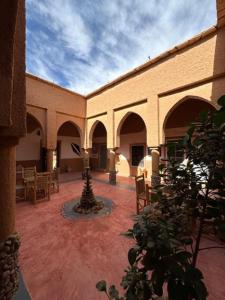 un bâtiment avec une cour dotée de chaises et d'une fontaine dans l'établissement Riad Nkob, à Nkob