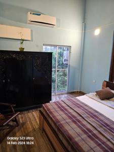 a bedroom with a large flat screen tv on a bed at Kevin's Place in Seeduwa