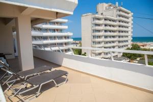 a chair on a balcony with a view of a building at Hotel Ambasador Mamaia in Mamaia