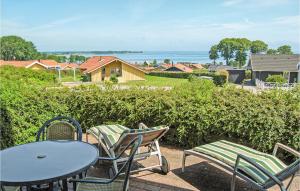 een tafel en stoelen op een patio met uitzicht op een huis bij Stunning Home In Sjlund With House Sea View in Hejls