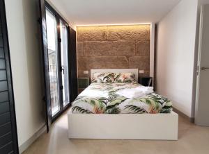 a bedroom with a bed with a large window at Cánovas 21 in Carballino