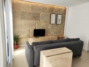 sala de estar con sofá y pared de ladrillo en Cánovas 21, en O Carballiño