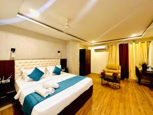 a hotel room with a large bed and a chair at Rainbow Tower Hotel Airport Road in Hyderabad