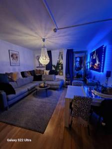 a blue living room with a couch and a table at Sjarmerende leilighet i hjerte av Tønsberg by in Tønsberg