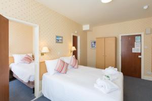 a hotel room with two beds with towels on them at Eliot Hotel in Newquay