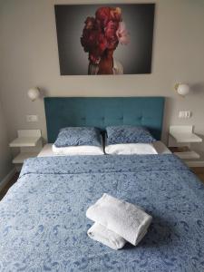 a bedroom with a blue bed with two pillows on it at Apartament Margot - Centrum in Tarnów