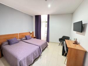 Schlafzimmer mit einem Bett, einem Schreibtisch und einem TV in der Unterkunft Catalunya in Barcelona