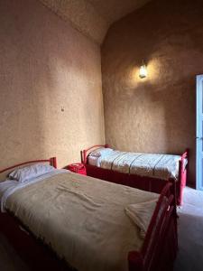 1 dormitorio con 2 camas en una habitación con ventana en Riad Nkob, en Nkob