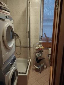 een badkamer met een douche en een wasmachine bij apartment close to the castle in Bratislava