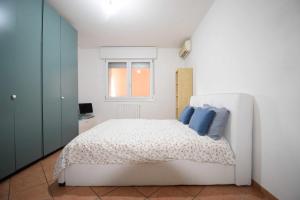 ein Schlafzimmer mit einem weißen Bett mit blauen Kissen in der Unterkunft Casa Gandolfi in Castello dʼArgile