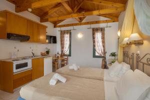 two beds in a room with a kitchen and a kitchen at Irida Aparthotel Malia by Estia in Malia