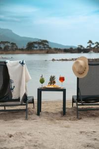 two chairs and a table on the beach with a hat at Beach 222 Oludeniz in Fethiye