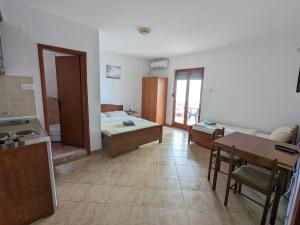 a room with a kitchen and a room with a table at Apartments Normannia in Dobra Voda