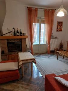 a living room with a fireplace and orange curtains at Deluxe Appartament near Racetrack 110 mq 4-5 People in Imola