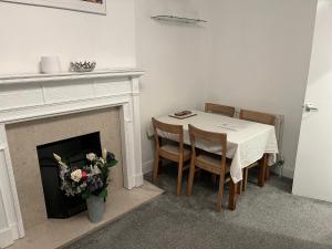 een eetkamer met een tafel en een open haard bij Lovely 1 bedroom flat in quiet Wimbledon in Londen