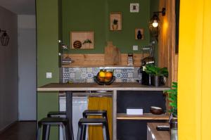 uma cozinha com paredes verdes e um balcão com bancos em C-FORTY - piscine - plage em Gassin