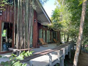 a house with a wooden porch with trees on it at Teak@Teak in Ban Cha-om