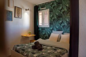 a bedroom with a bed with a green wall at C-FORTY - piscine - plage in Gassin