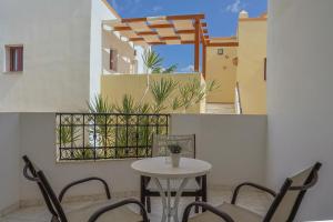 a patio with a table and chairs on a balcony at Irida Aparthotel Malia by Estia in Malia