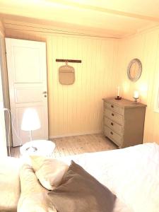 ein Schlafzimmer mit einem Bett, einer Kommode und einer Lampe in der Unterkunft Svalemosej 42 in Strøby Egede