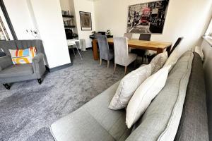 a living room with a couch and a dining room table at Green Haven Villa - 4BR Spacious House with Hot tub, Ample Parking, Air Condition, WIFI, Netflix, Patio & Garden in Oxford