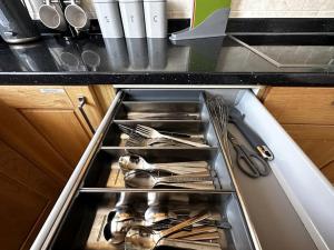 a drawer in a kitchen with utensils in it at Green Haven Villa - 4BR Spacious House with Hot tub, Ample Parking, Air Condition, WIFI, Netflix, Patio & Garden in Kidlington