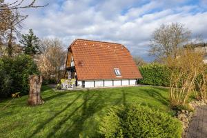 a house with an orange roof on a green yard at Ferienhaus Elbidylle in Bachenbrock