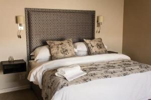 a bedroom with a large bed with a large headboard at Kerala Hotel in Bloemfontein