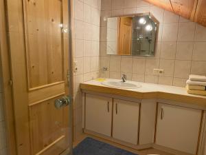 W łazience znajduje się umywalka i lustro. w obiekcie Klausmoarhof w mieście Leisach