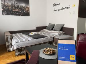 una habitación con 2 camas y una mesa con un plato de comida en Dini apartments, en Novi Sad