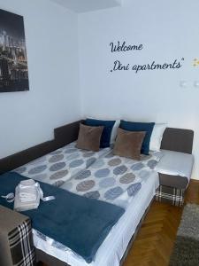 Una cama en una habitación con un cartel que lee experimentos de bienvenida en Dini apartments, en Novi Sad
