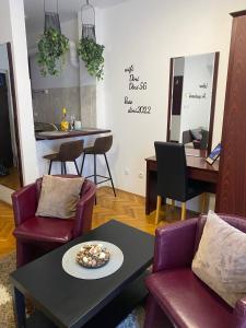 sala de estar con mesa, sillas y barra en Dini apartments, en Novi Sad