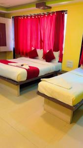 two beds in a room with red curtains at Hotel Icon International Airport Mumbai in Mumbai